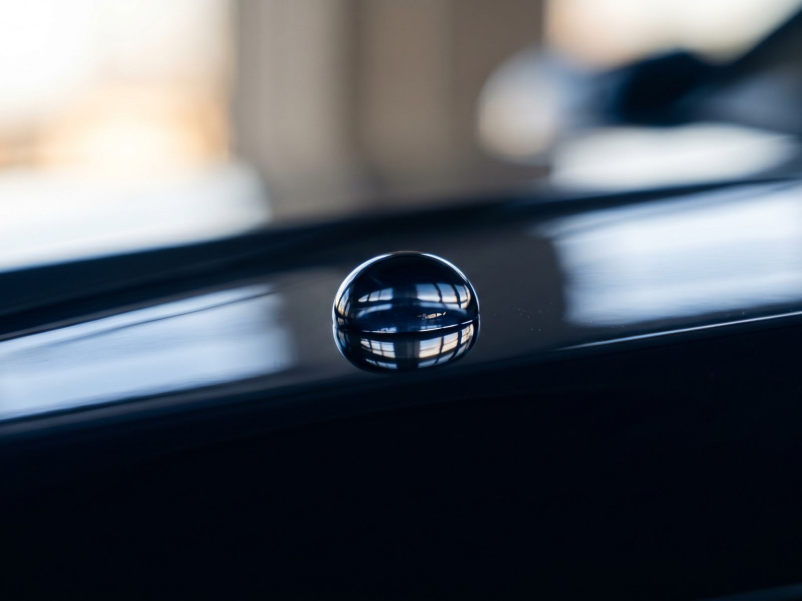 Vanddråbe på sort billak — caustic refleksion